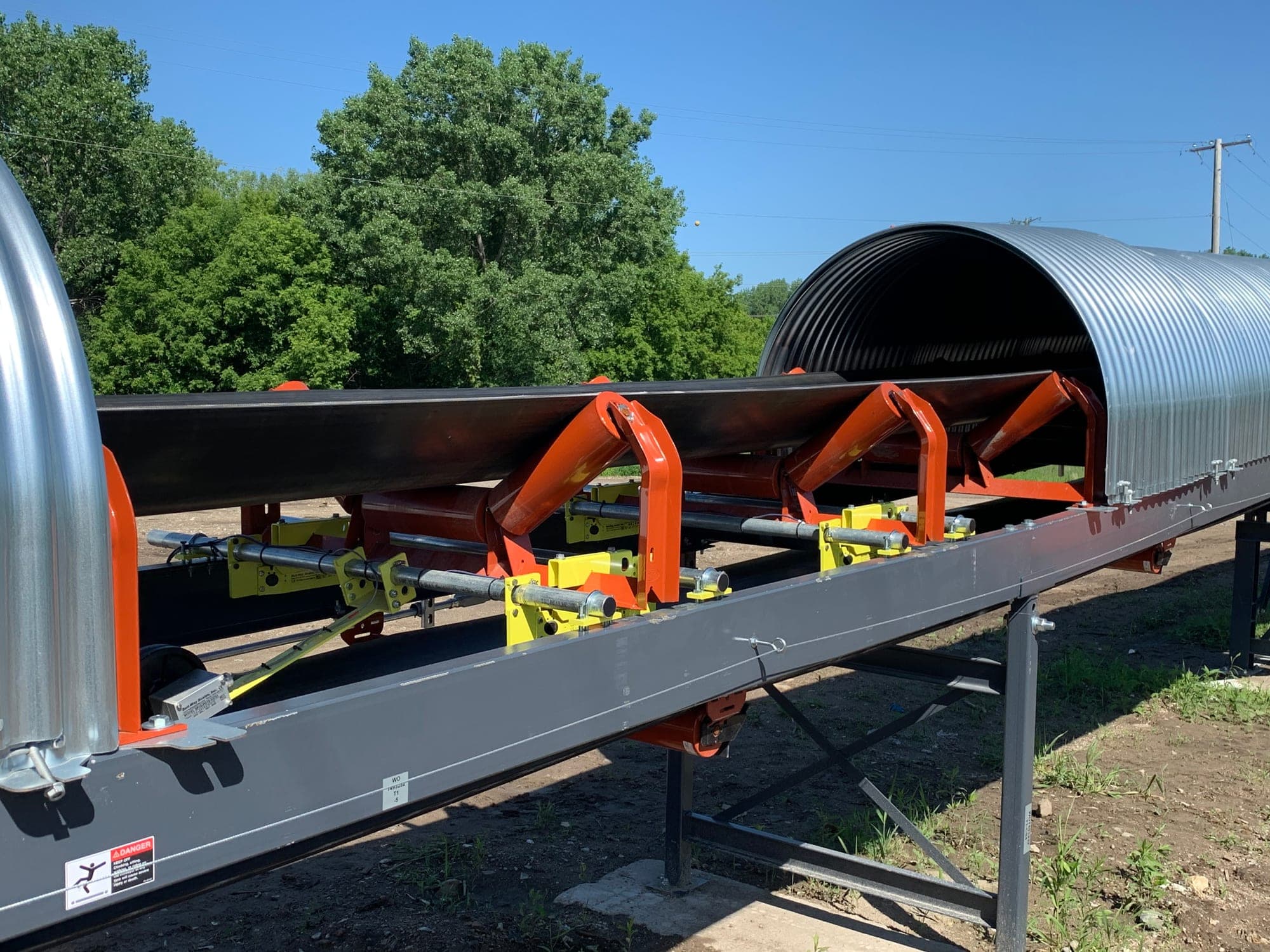 Belt scale weighbridge modules mounted on troughing idlers under a covered conveyor