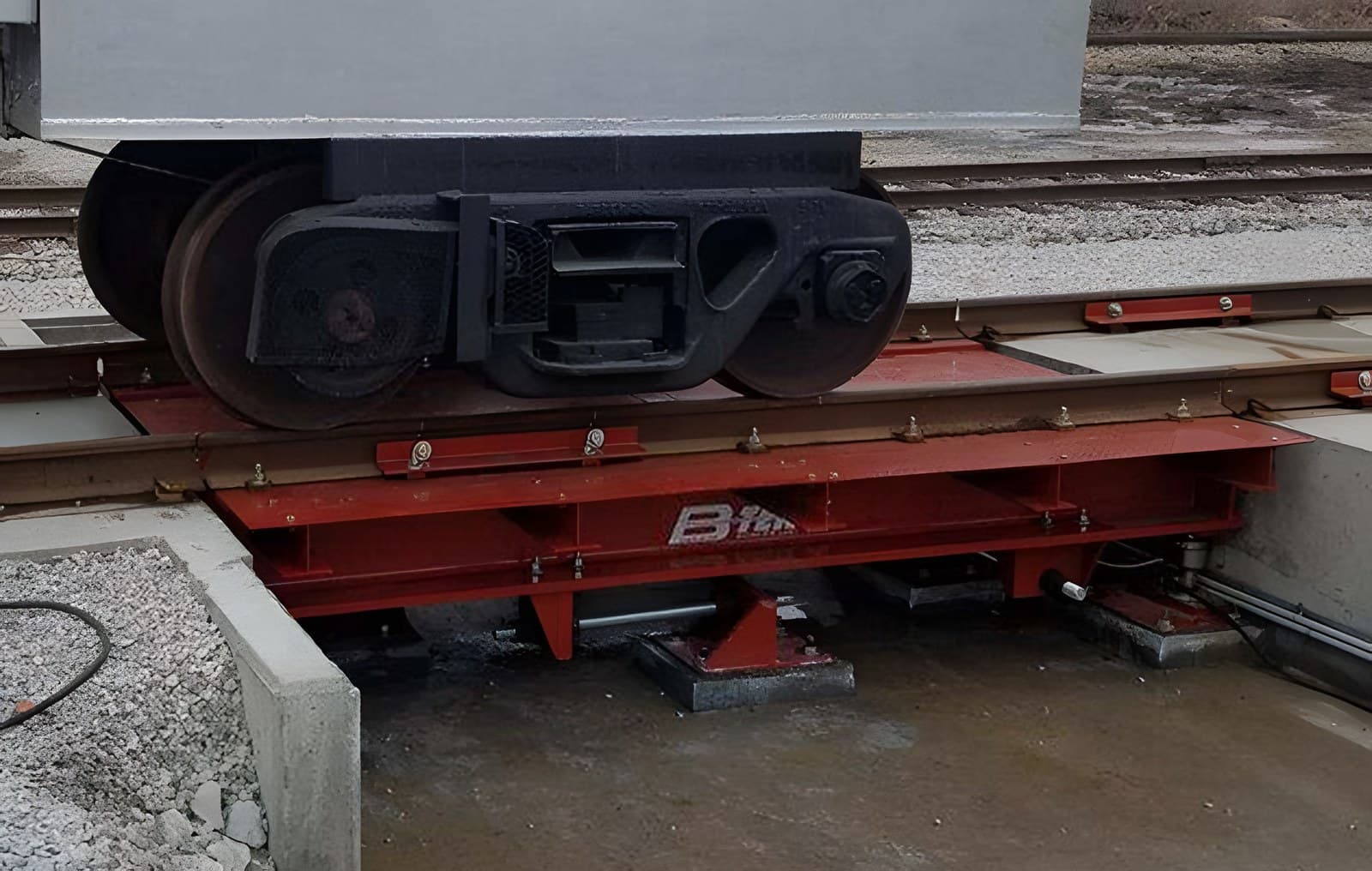 Test cart wheels on a rail scale weighbridge set on an open-sided concrete foundation