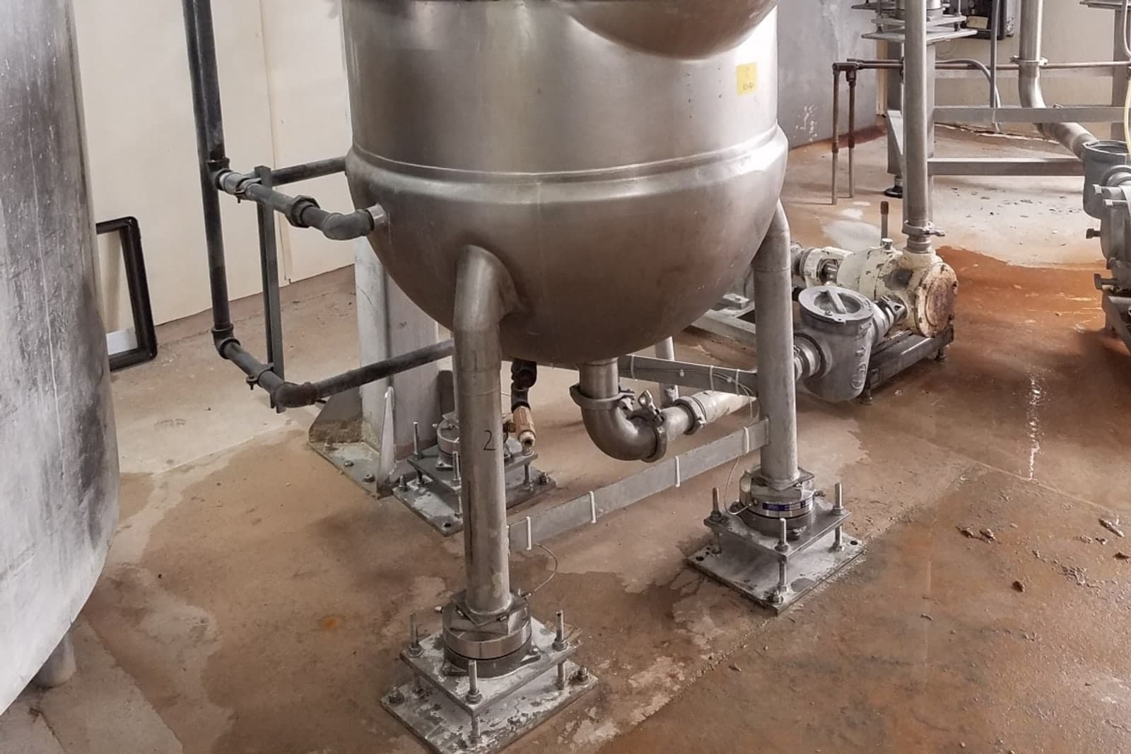 Stainless process vessel resting on weigh modules at each leg in a food plant