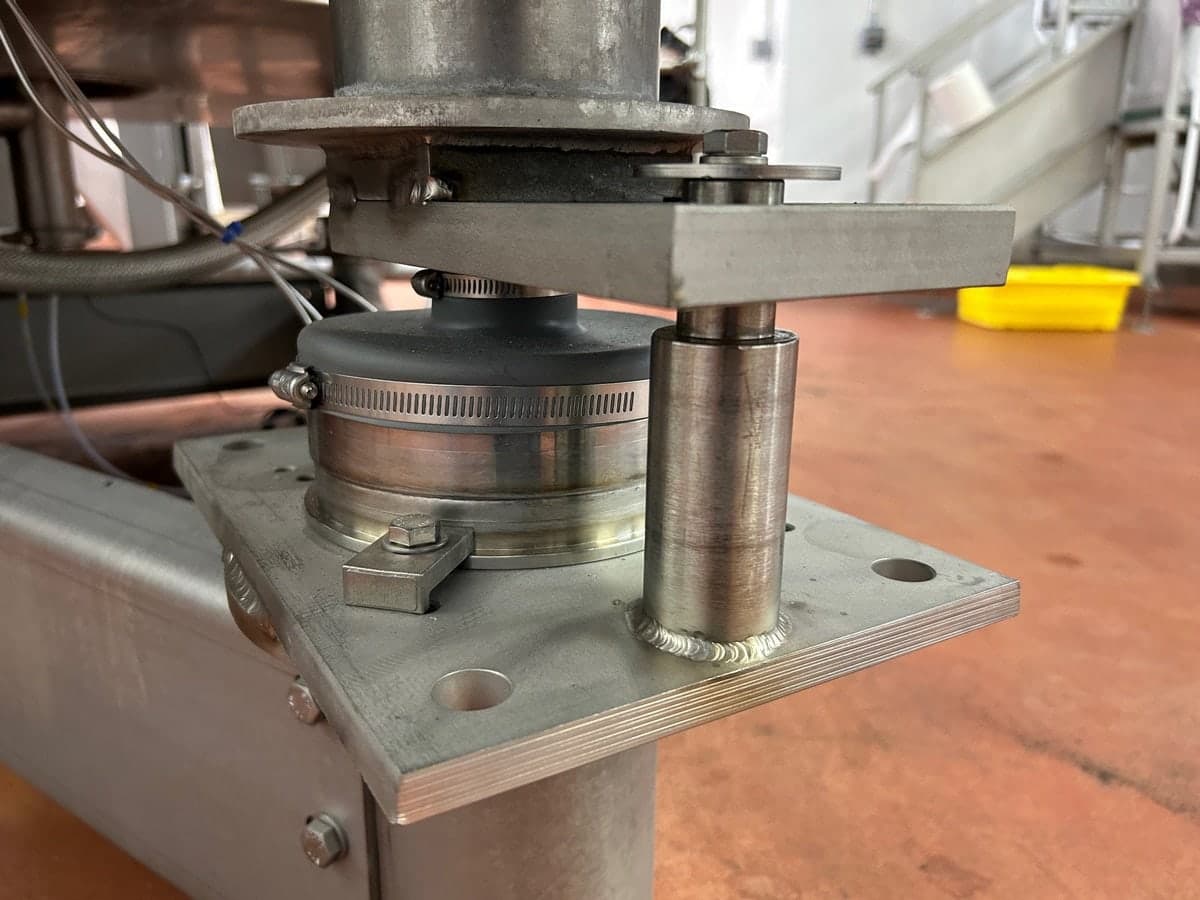 Weigh module and check rod under a vessel leg, holding the vessel steady while letting it weigh freely