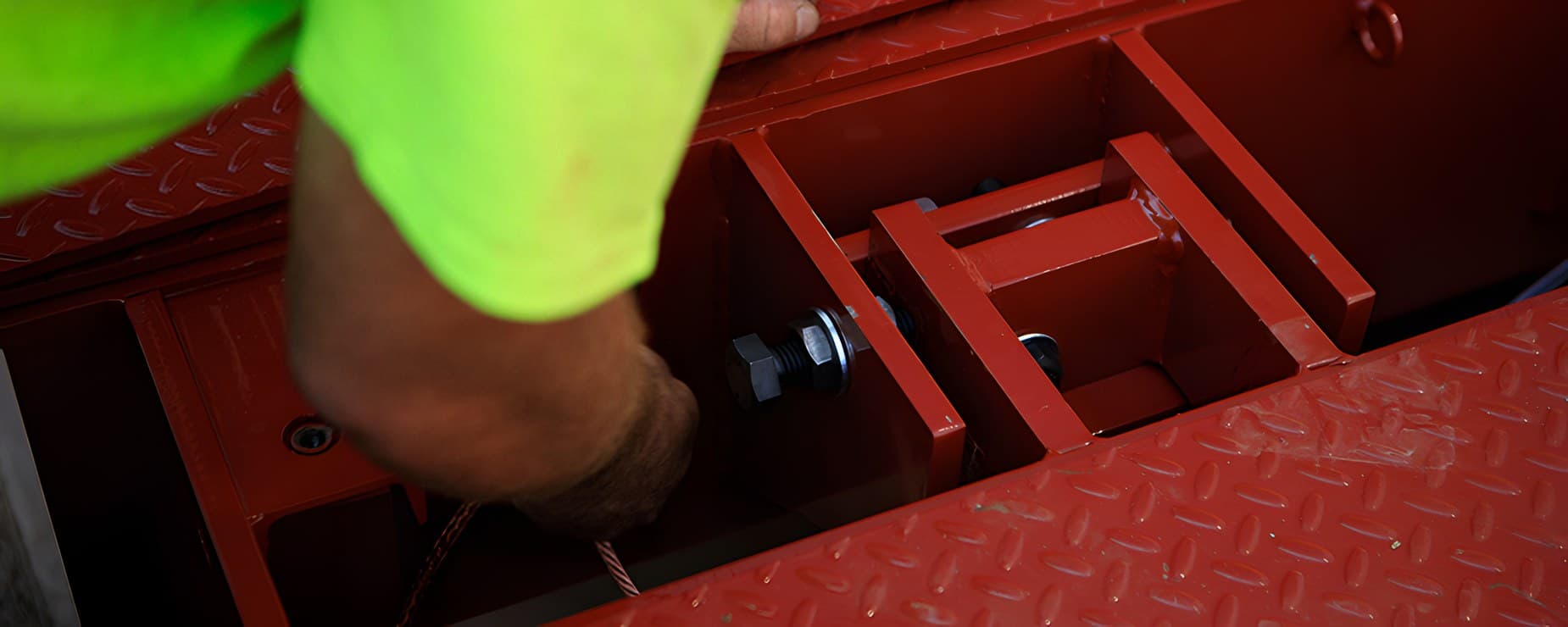 Technician working inside an access pocket on a steel truck scale deck